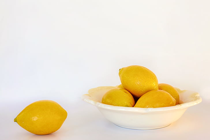 several lemons on white ceramic bowl