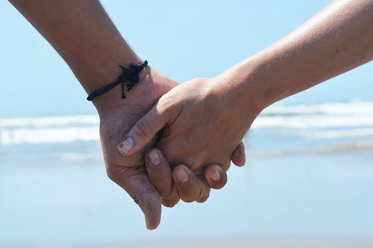 photo of holding hands near seashore