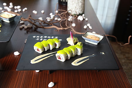 serving of sushi on top of black plate