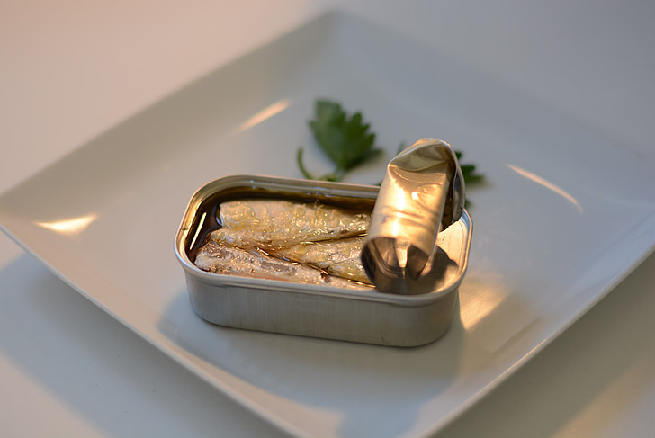 opened sardine can near parsley leaves