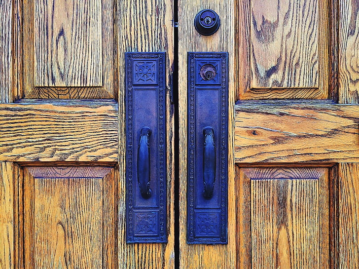 brown wooden doors with two blue metal door handles
