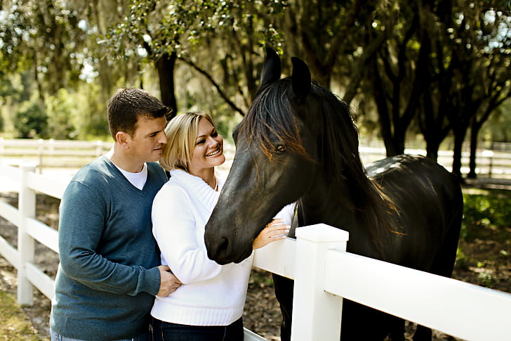 man and woman standing in front of horse