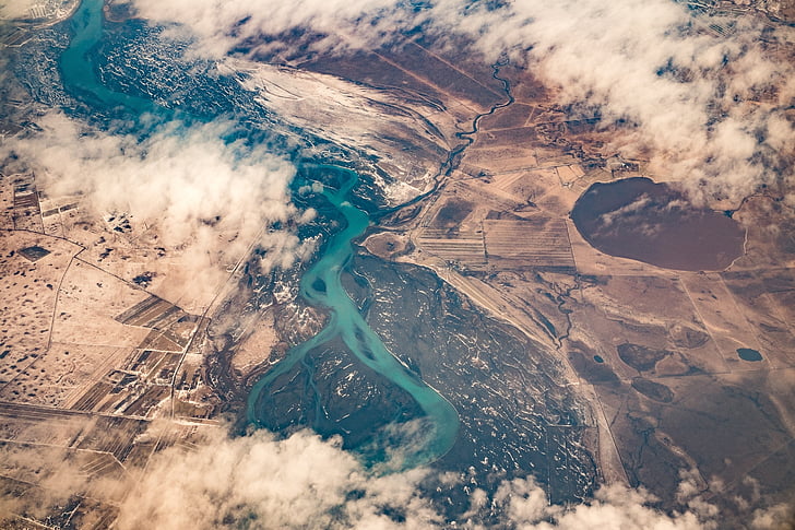 aerial photography of river between brown terrains