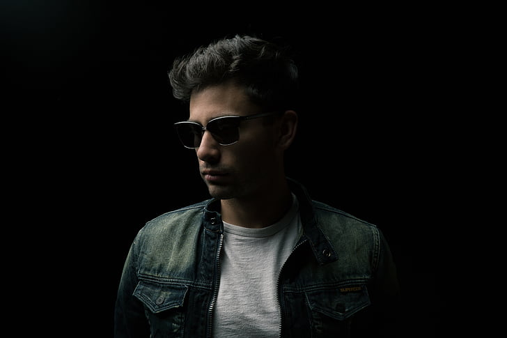 black haired man in blue denim jacket and black sunglasses