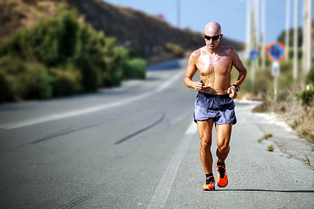 man wearing shorts running on pavement