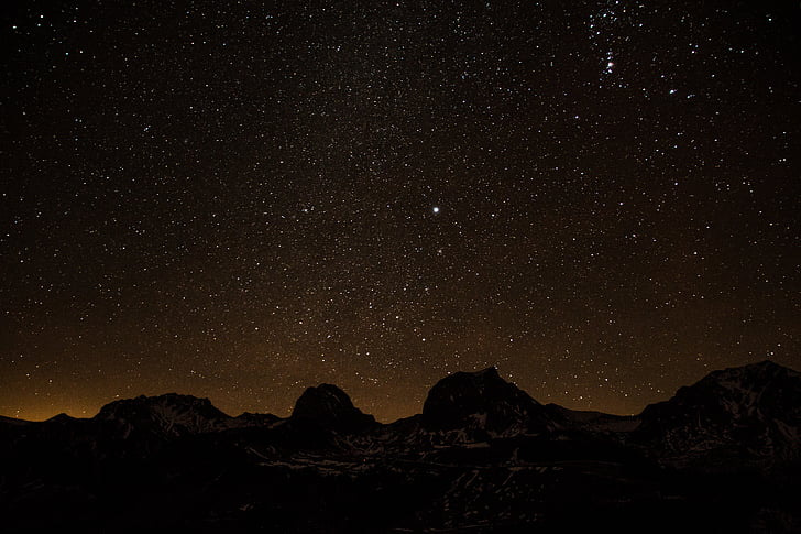 silhouette of boulder under star night