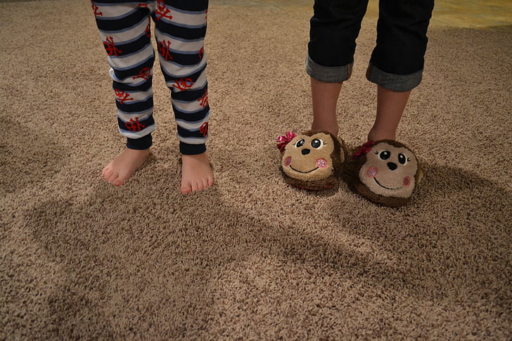 two children standing on brown rug