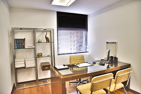 brown wooden executive desk and two vacant chairs