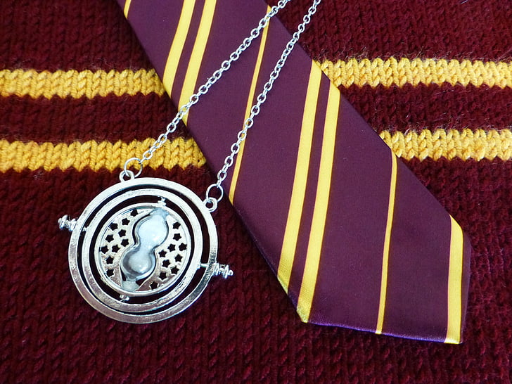 silver-colored pendant on necktie