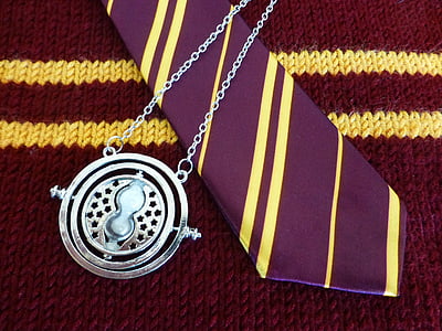 silver-colored pendant on necktie