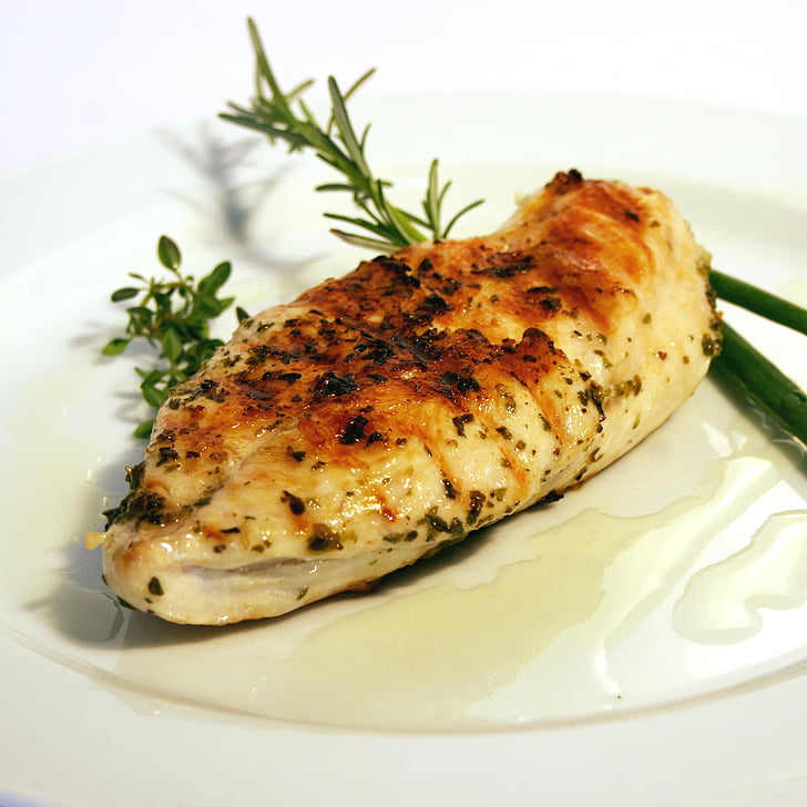 grilled chicken breast in white ceramic plate