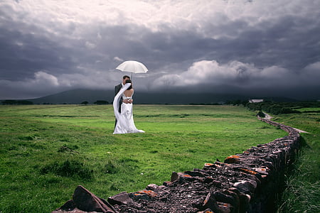 bride and groom under white umbrella