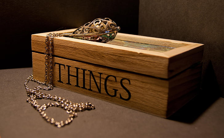 gold necklace on brown wooden Things-printed box