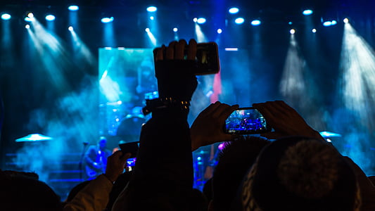 group of people holding smartphones watching concert