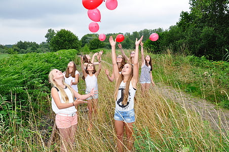 photo of girls flying balloons