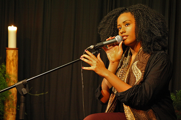 woman holding black microphone with stand