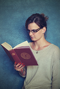 woman wearing eyeglasses reading book
