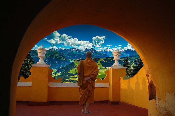 monk wearing brown coat in balcony looking on cloud