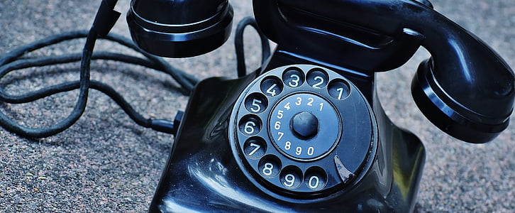 vintage black rotary phone on gray surface