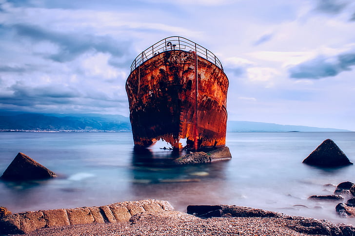 brown ruined vessel on bodies of water landscape photography