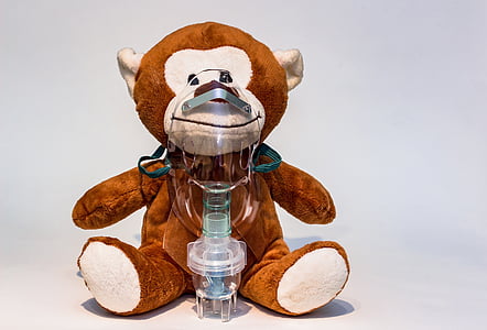 brown and white monkey plush toy with nebulizer