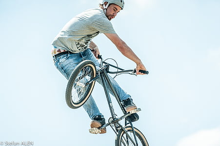 man performing stunts using black BMX bike