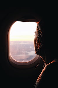 woman looking at airplane window photo during daytime