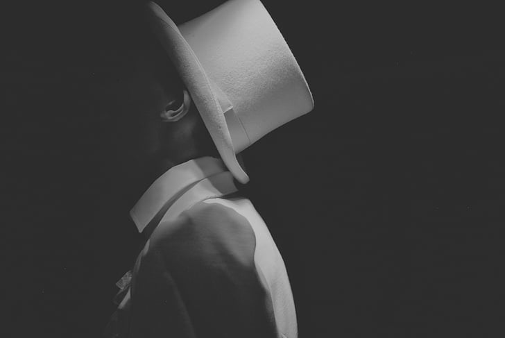grayscale photo of man wearing fedora hat