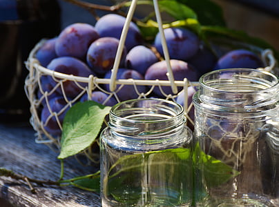 bunch of purple fruits near on two glass mason jars