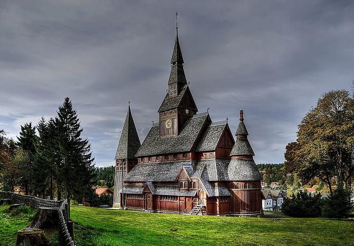 black and brown church surrounded by green trees