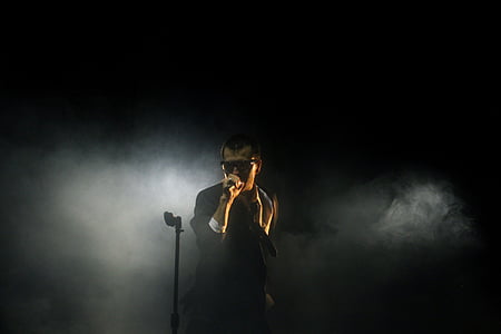 man wearing black suit holding microphone