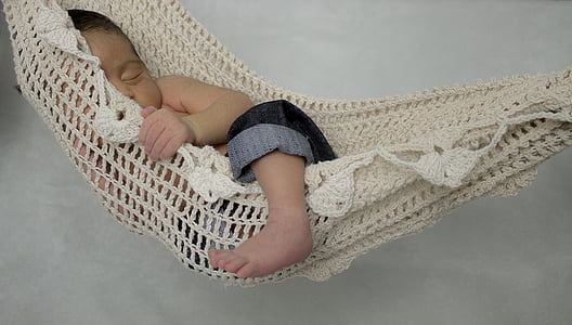 baby on white knit hammock