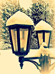 snow-covered black post lamp