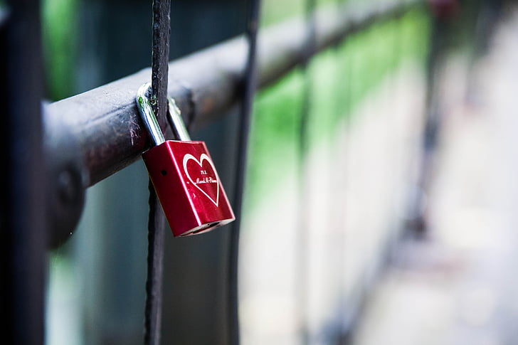 shallow focus of red and silver padlock