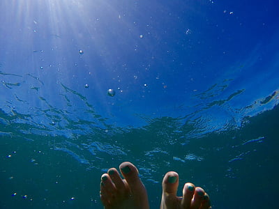 person's feet on water