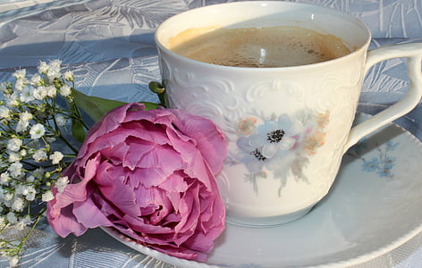 white floral ceramic cup filled near flower