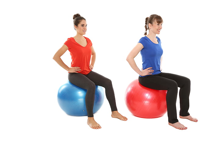 two women sitting on two exercise balls