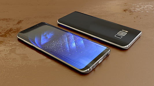 two black smartphones on brown surface
