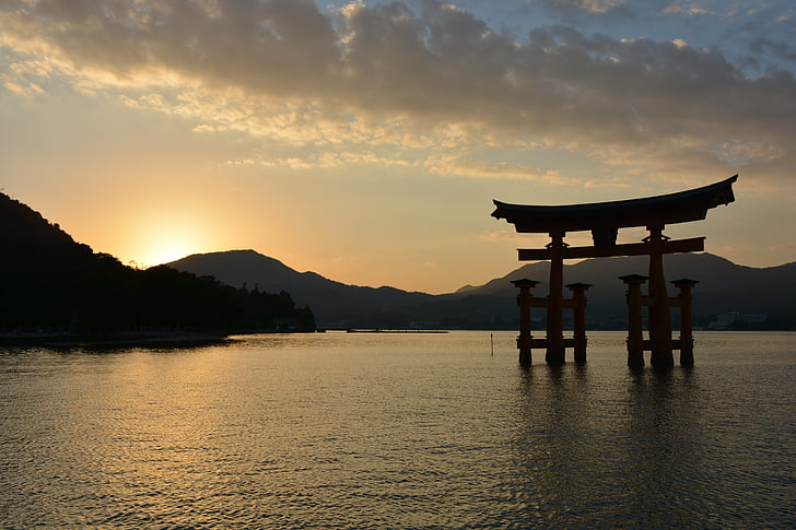 tori gate in body of water during golden hour