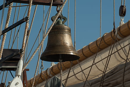 brass-colored bell hanged on brown rack