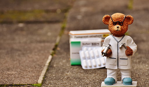 brown doctor bear figurine on selective focus photo