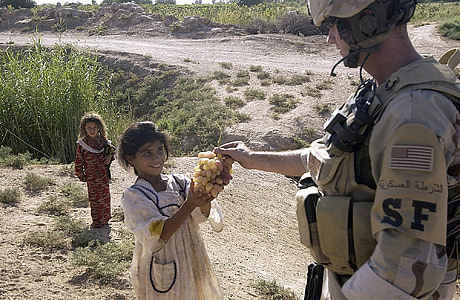 soldier give girl some fruit during daytime