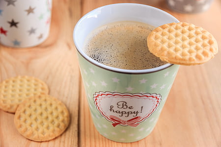 biscuit on green cup filled with coffee