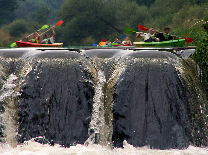people riding on kayak in river