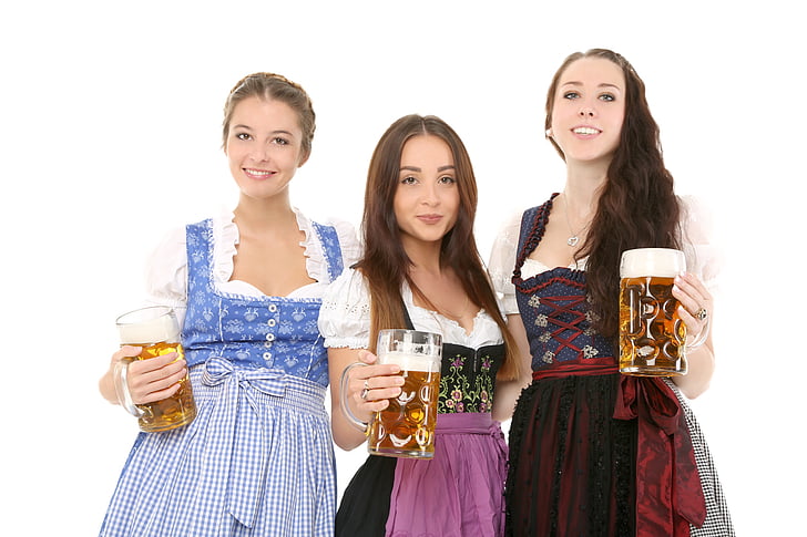 three women wearing dresses standing while folding glass tankards filled with beers