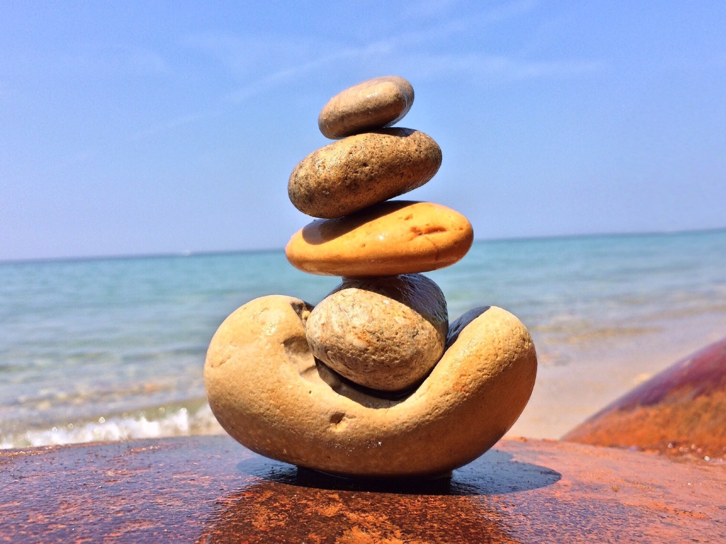 Premium Photo  A person stacking rocks on a beach.