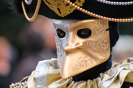person wearing gold and black mask