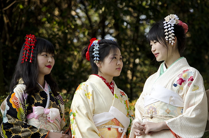 three black haired woman wearing kimono