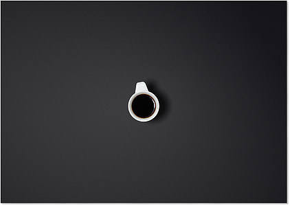 filled white cup on top of black surface