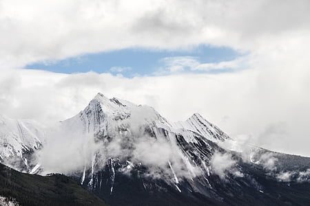 mountain covered with snow near clouds